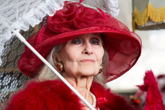 Grete Brunvoll i rød hatt og parasol